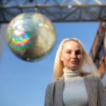 Portret młodej kobiety stojącej przed dekoracją w mieście