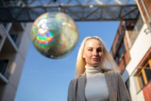 Portret młodej kobiety stojącej przed dekoracją w mieście