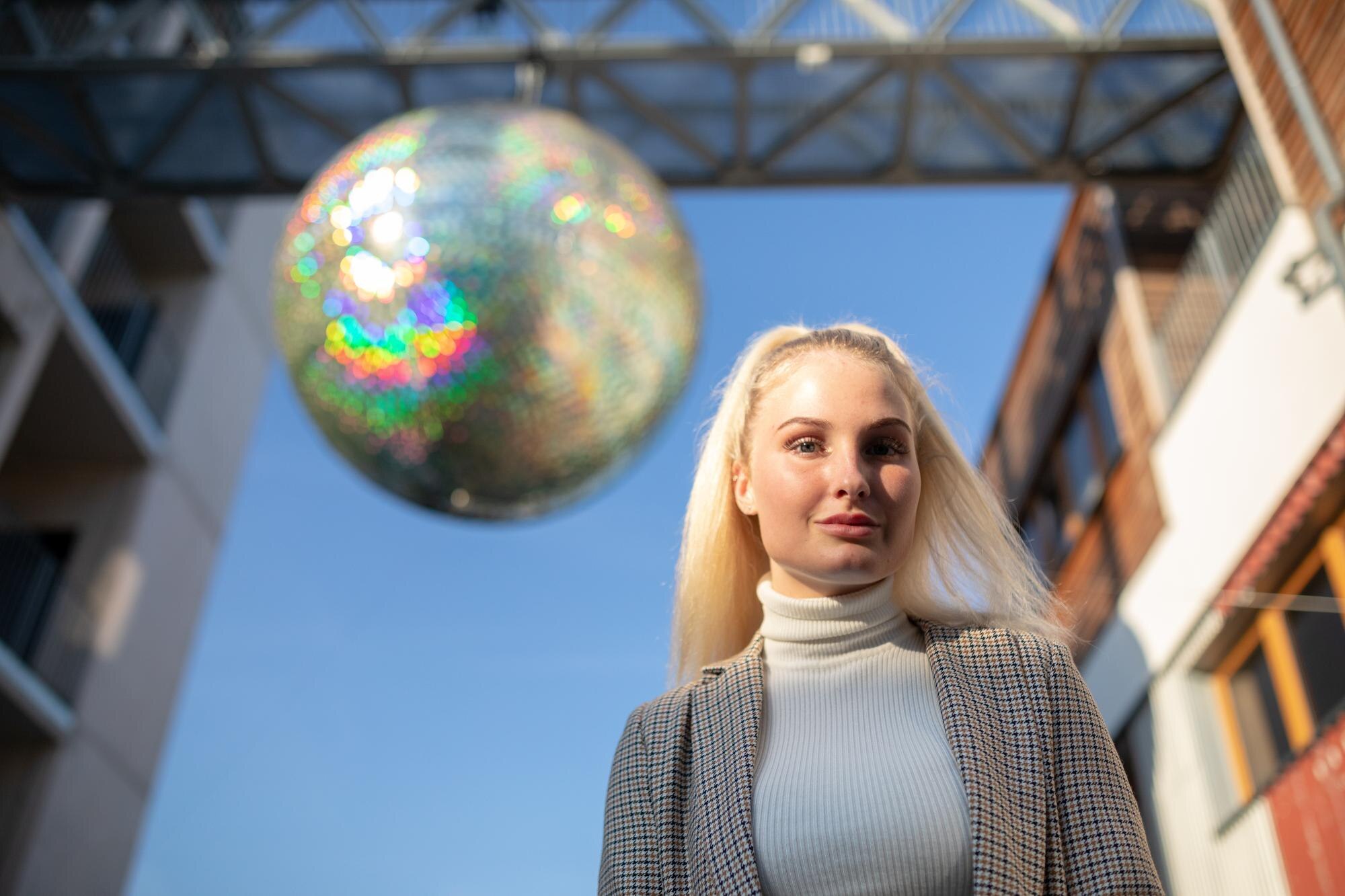 Portret młodej kobiety stojącej przed dekoracją w mieście