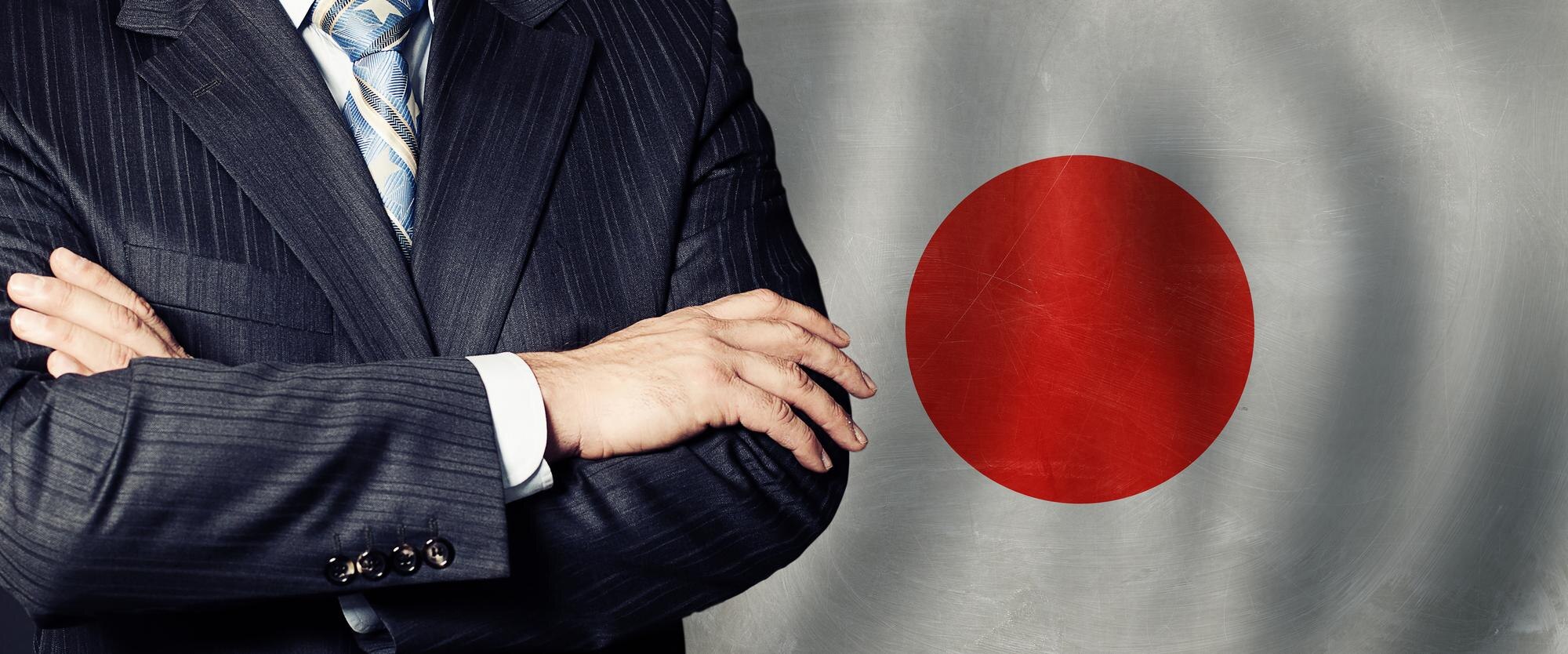 Ręce mężczyzn na tle japońskiej flagi tło biznes polityka i edukacja w Japonii koncepcja