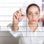 Ręka kobiety biznesu pisania listy na ekranie z markerem