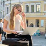 Młoda businesswoman z laptopem na zewnątrz, kobieta patrząc na ekran komputera uśmiechnięta i rozmawia komunikacji wideo. Wideokonferencja, biznes, freelance, koncepcja stylu życia