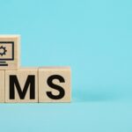 Akronim CMS na drewnianych kostkach na niebieskim tle Często zadawane pytania Koncepcja obsługi klienta i wsparcia dla biznesu Akronim CMS na drewnianych kostkach Content Management System