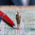 Miniaturowy polityk na głosowaniu wyborczym z czerwonym piórem