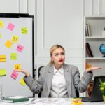 Marketing młoda urocza blondynka w szarym garniturze w biurze zdezorientowana rozmowa z kimś