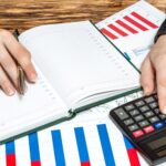 Biznes kobieta liczy na kalkulatorze i zapisuje informacje finansowe w notatniku Koncepcja biznesowa