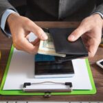Biznesmen trzymający dolary z portfelem