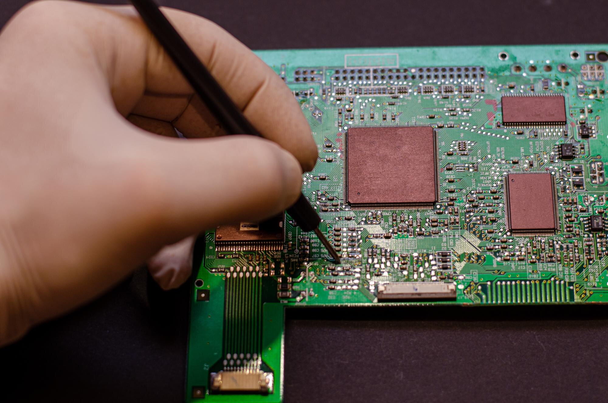 Naprawa telefonów komórkowych i różnych gadżetów elektronicznych Chip z urządzenia elektronicznego leży na stole na czarnym tle
