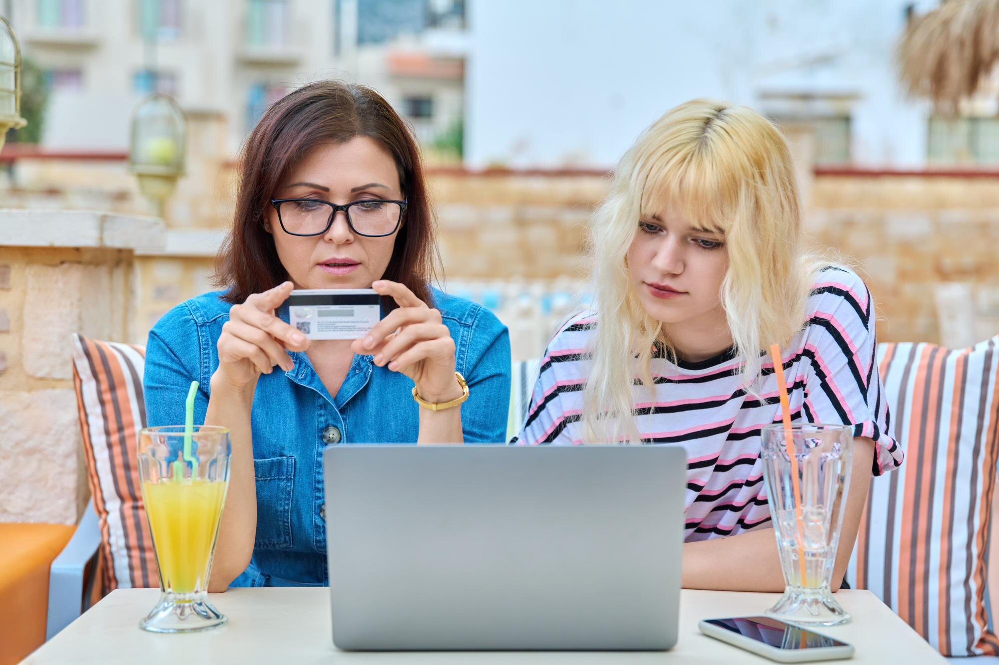 Matka i nastoletnia córka robią razem zakupy online za pomocą laptopa