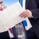Biznesmeni prowadzący dyskusję, trzymając dokument z planem