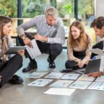 Group of young business people working on new project sitting with financial documents