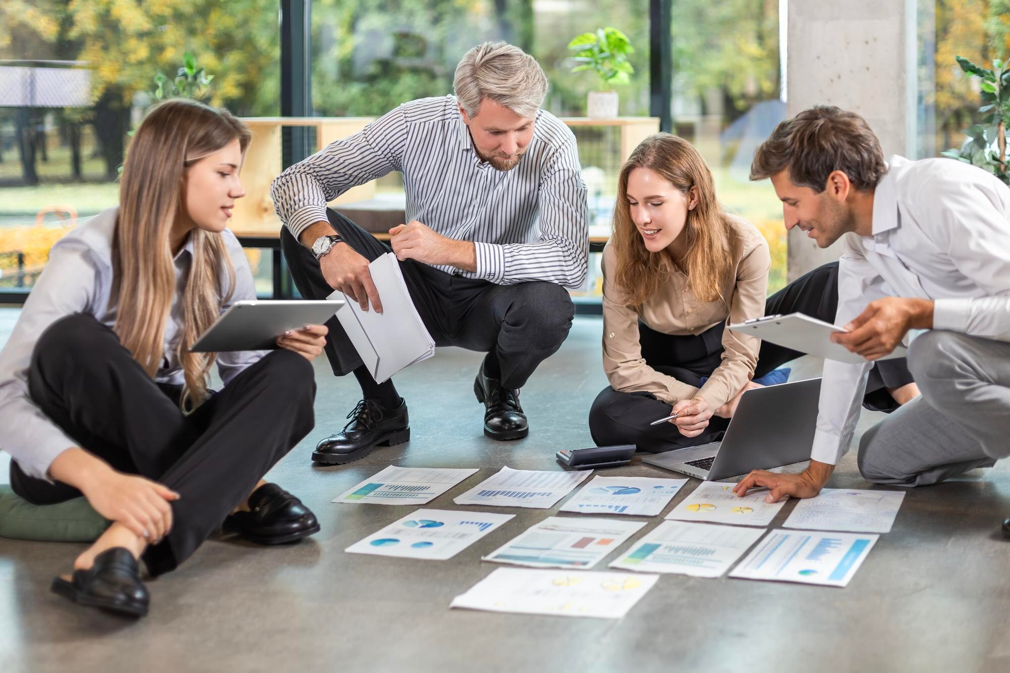 Group of young business people working on new project sitting with financial documents