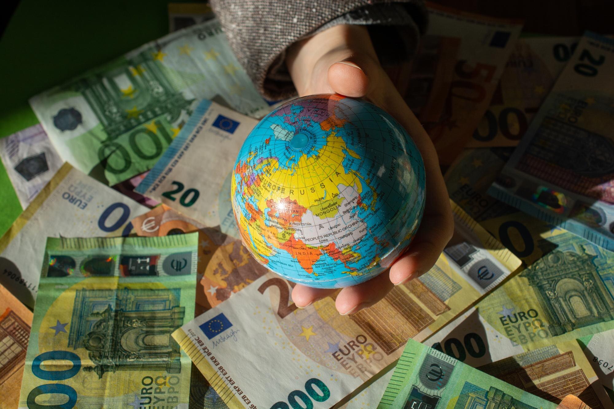 Euro jako waluta Unii Europejskiej i model globusa w ręku