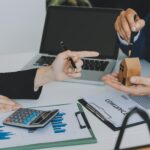 Kobieta trzyma się za ręce, trzymając model domu mały miniaturowy biały domek z zabawkami Wymarzone ubezpieczenie hipoteczne na przeprowadzkę i koncepcję nieruchomości